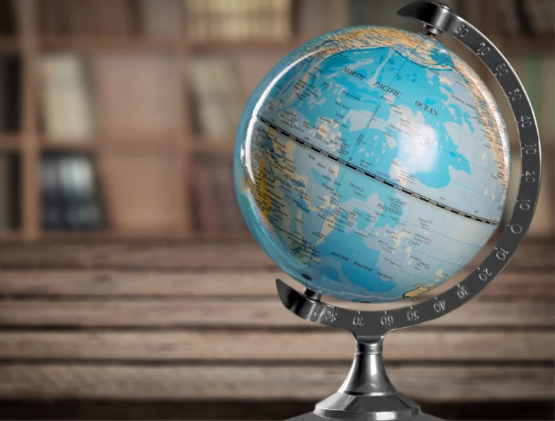 Henry lever-action rifle on desk next to world globe, showcasing international availability