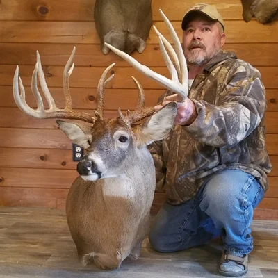 Experienced hunter posing with a large, impressive deer trophy