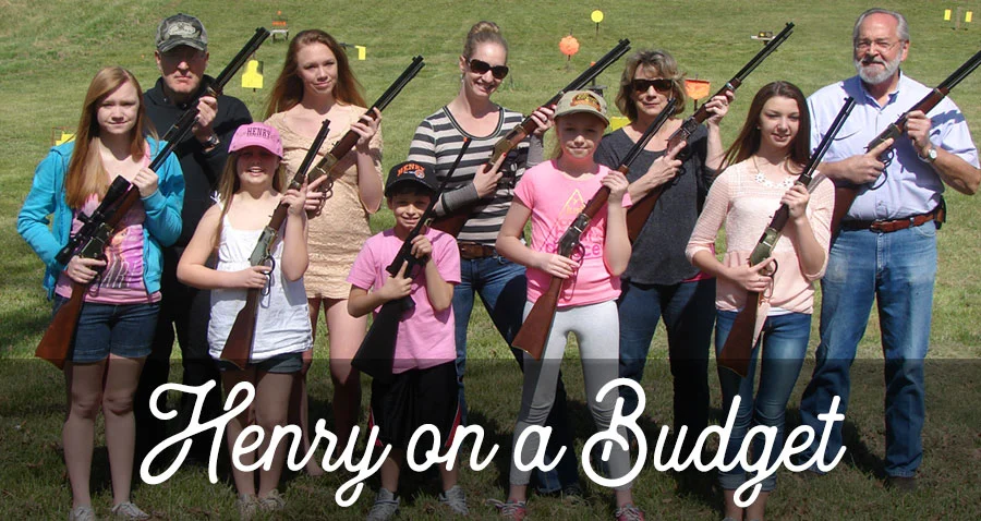 Large family group holding various firearms and posing together outdoors
