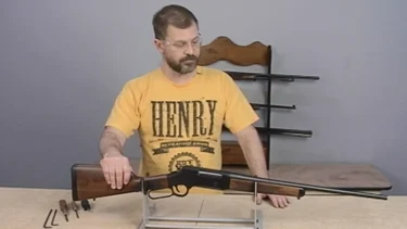 Man demonstrating proper maintenance of Henry lever-action rifle in instructional video