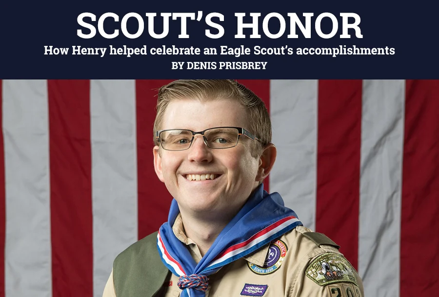 Eagle Scout wearing medal and uniform holding Henry Repeating Arms rifle