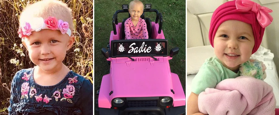 Young girl in pink dress sitting in pink toy car