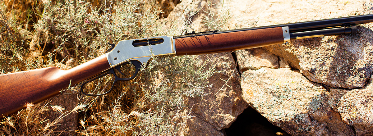 Henry lever-action rifle on rocky terrain, ideal for hunting