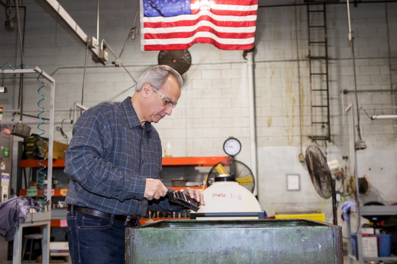 Henry President Anthony Imperato inspecting parts