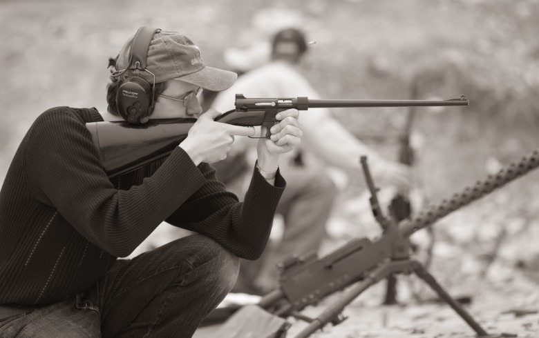 Black and white photo of a man aiming a Henry U.S. Survival AR-7