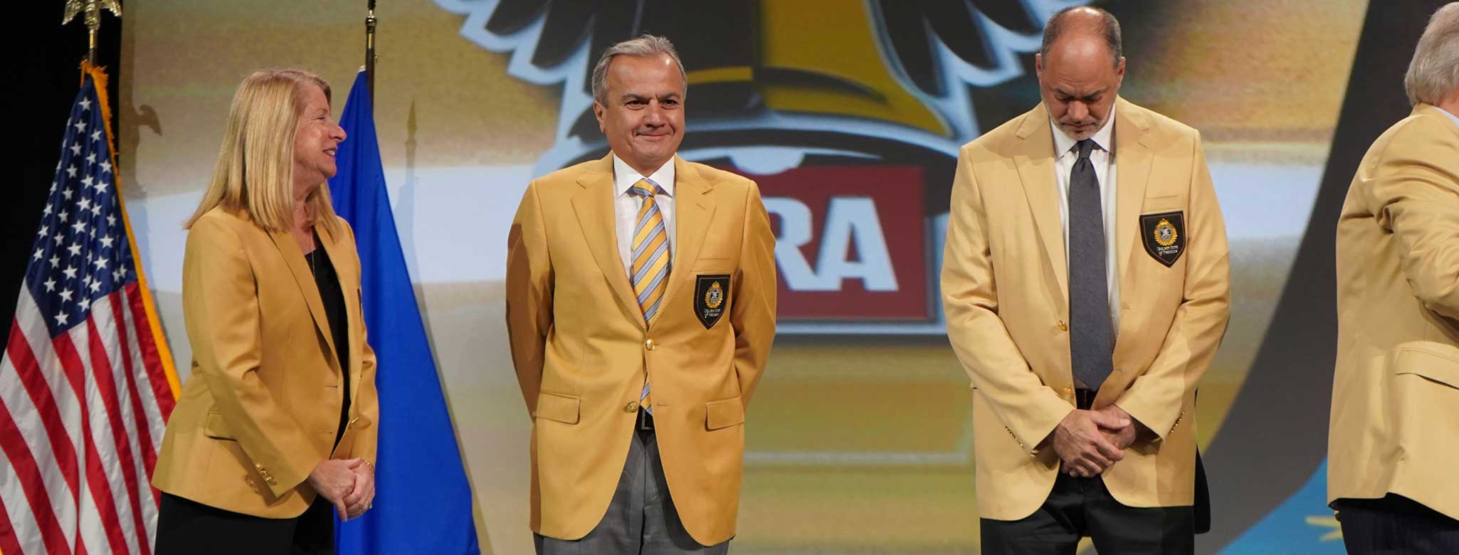 Men in golden suit jackets at NRA gold jacket award ceremony for Henry Repeating Arms president