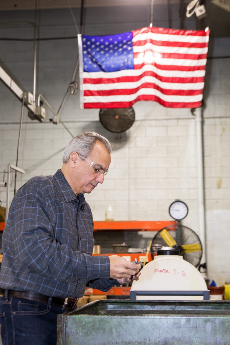 Anthony Imperato inspecting the finish on a part.