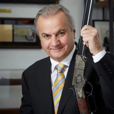 Anthony Imperato holding up engraved rifle.