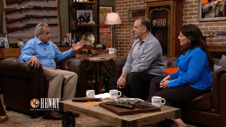 Group of people discussing and showcasing Henry rifles and firearms