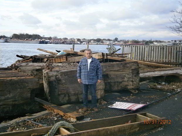 Anthony Imperato stands in front of a damaged pier.