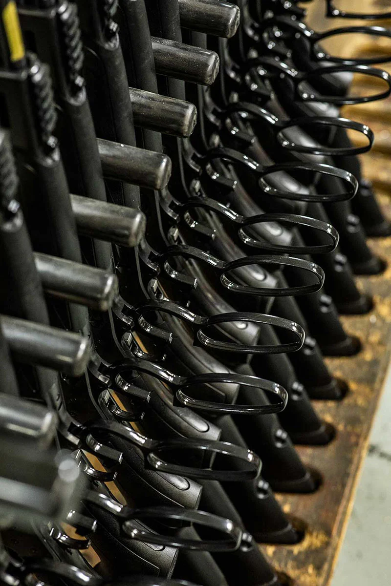 Rows of Henry rifles on a factory production line, showcasing the company's domestic craftsmanship and attention to detail.