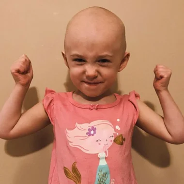 Smiling child in pink shirt with arms raised, Henry firearms supporters