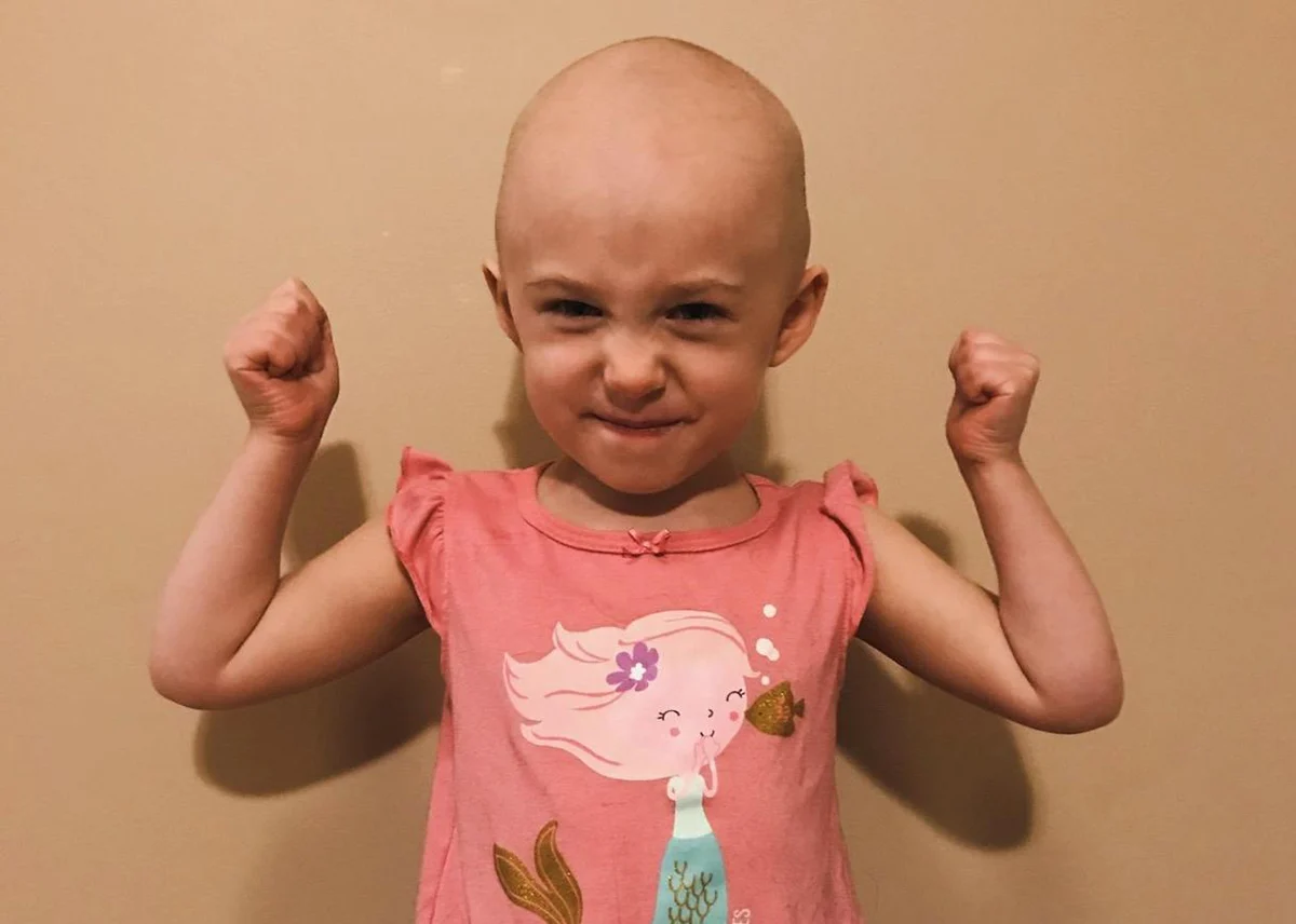 Smiling child holding nature-themed accessory in outdoor setting for Henry Repeating Arms charitable campaign