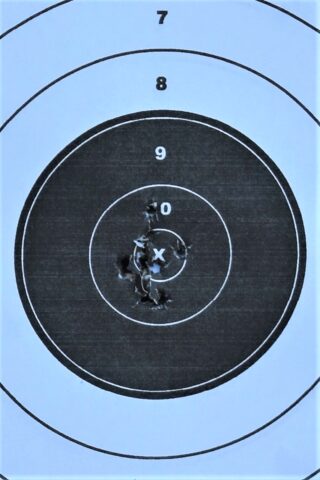 Holes in a paper target showing accuracy.