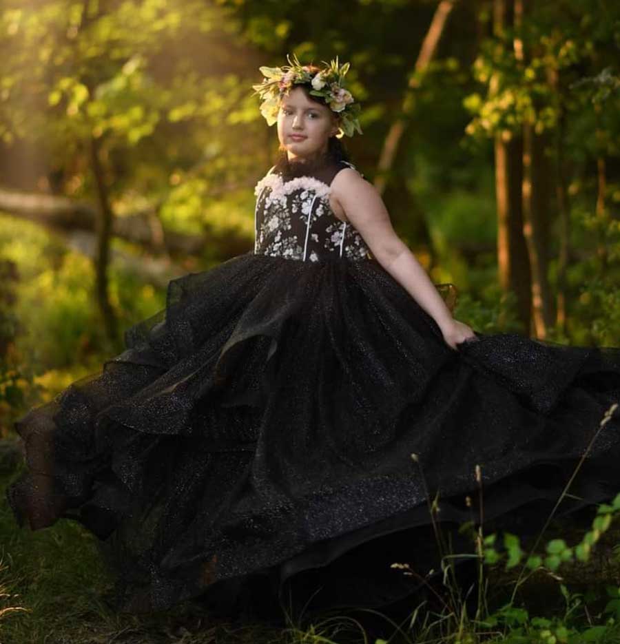 A young girl with her family members posing in front of a memorial wall