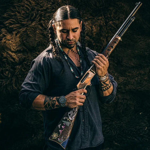 Man holding a painted rifle in his arms.