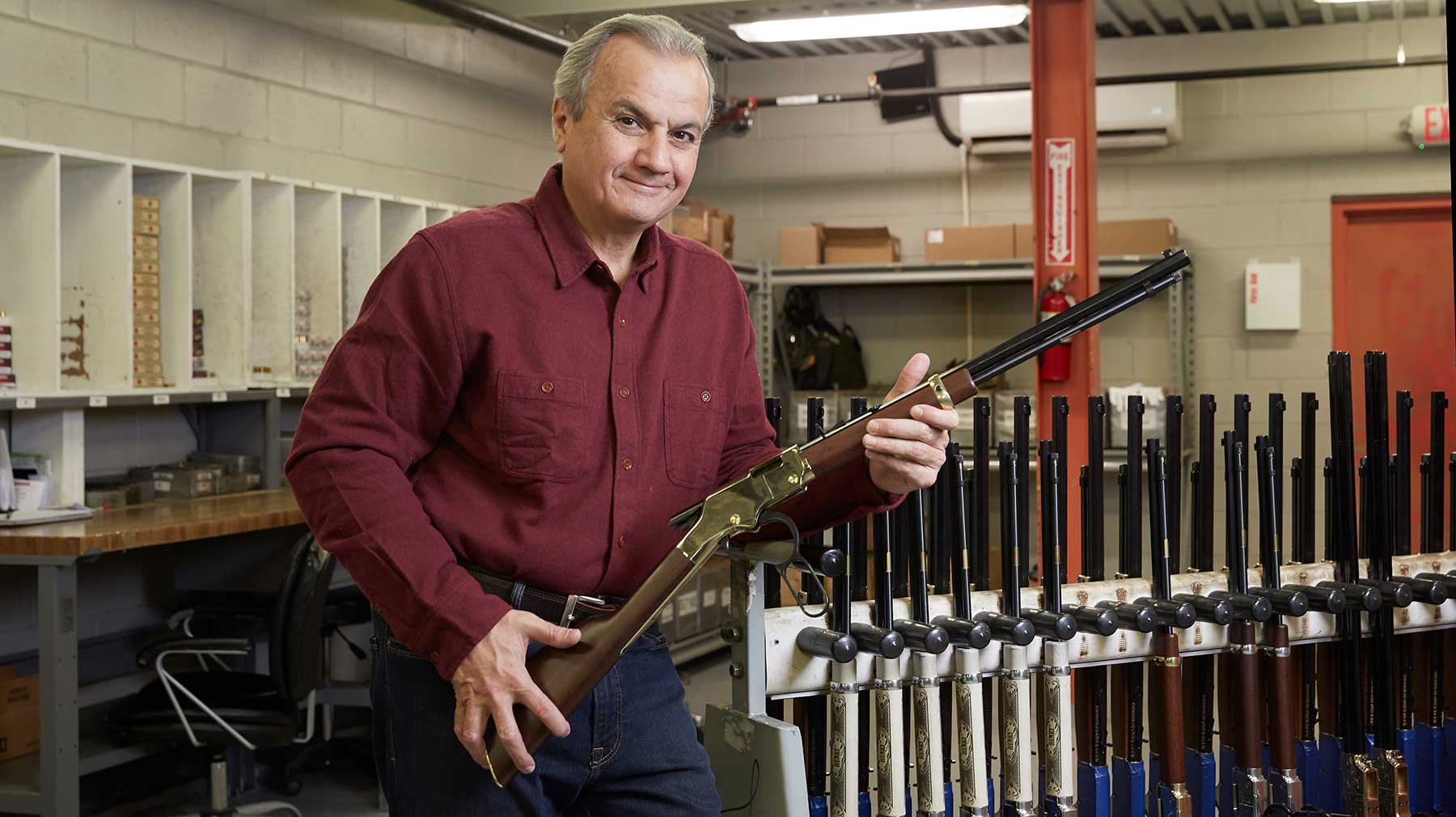 Henry Repeating Arms CEO Anthony Imperato standing in a rifle storage area