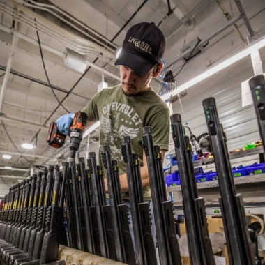 Man drilling chokes into shotguns at a Henry Repeating Arms factory