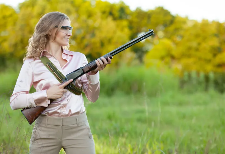 A woman holding a Henry Pump Action .22 Mag rifle.