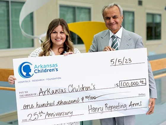 Representatives from Henry Repeating Arms company donate $100,000 check to Arkansas Children's Hospital on 25th anniversary