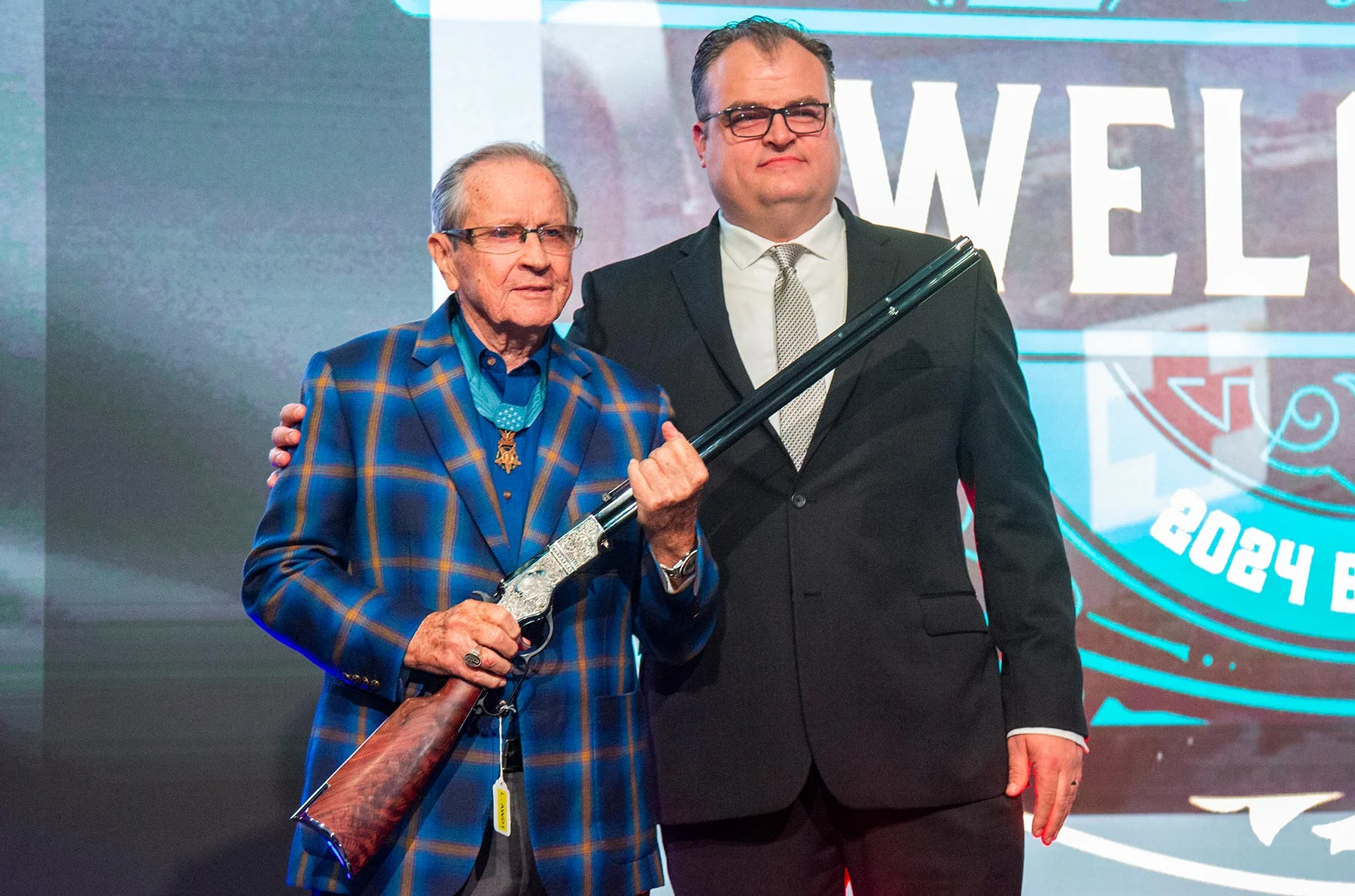 Three men in business suits standing with an award plaque displaying the Henry Repeating Arms logo and branding
