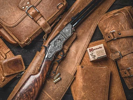 Iconic Henry lever-action rifle with vintage leather gear and accessories