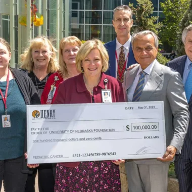 Group photo of Henry Repeating Arms employees presenting a large donation check to a non-profit organization