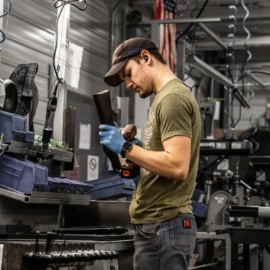 Firearms expert assembling a Henry rifle in a workshop, showcasing the brand's American-made quality and craftsmanship