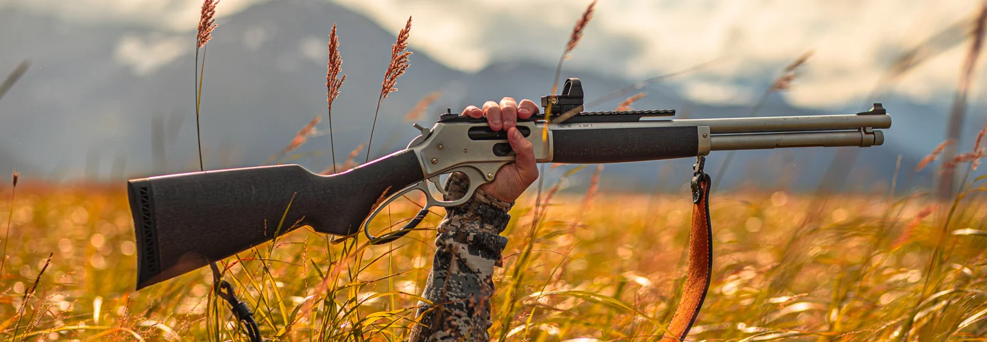 Henry Repeating Arms lever-action rifle in a field with autumn foliage