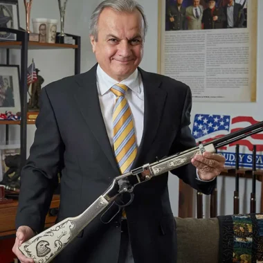 Senior executive of Henry Repeating Arms proudly displays American-made rifle, showcasing the company's commitment to high-quality firearms production in the USA