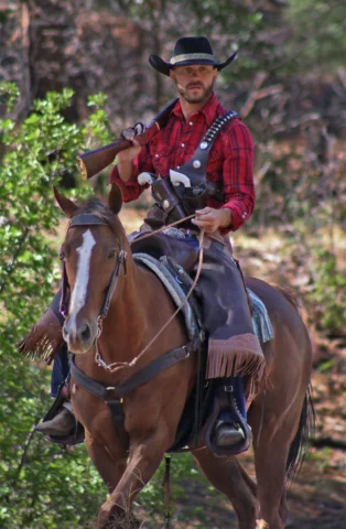 Cowboy figure wearing black hat and fur-lined jacket, looking to the side
