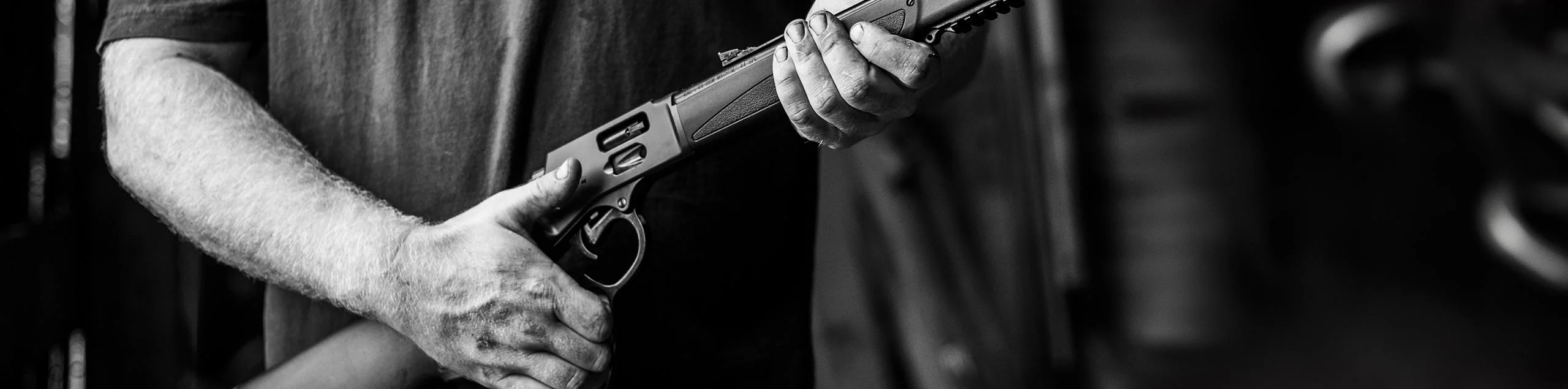 Close-up view of a person's hands gripping a lever-action rifle, symbolizing Henry Repeating Arms' firearms for hunting, target shooting, and self-defense