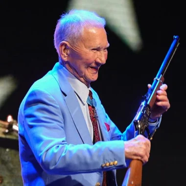 Henry Repeating Arms CEO Anthony Imperato smiling while holding a Henry lever-action rifle on stage