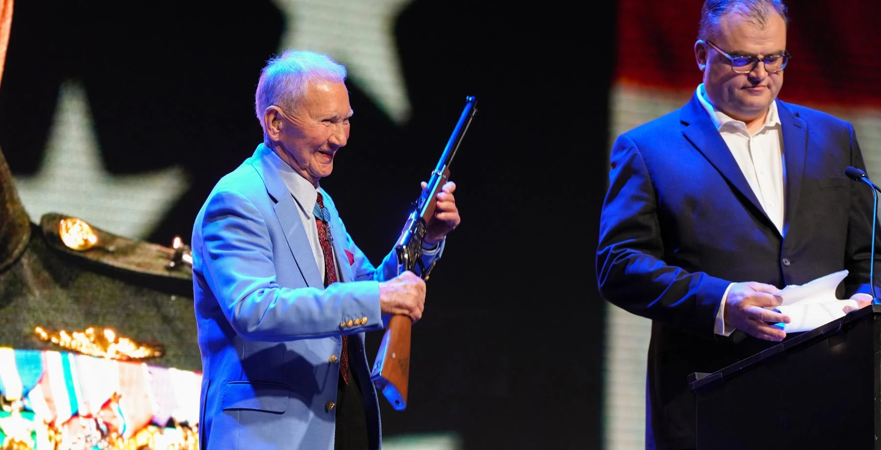 Three men in business suits standing with an award plaque displaying the Henry Repeating Arms logo and branding
