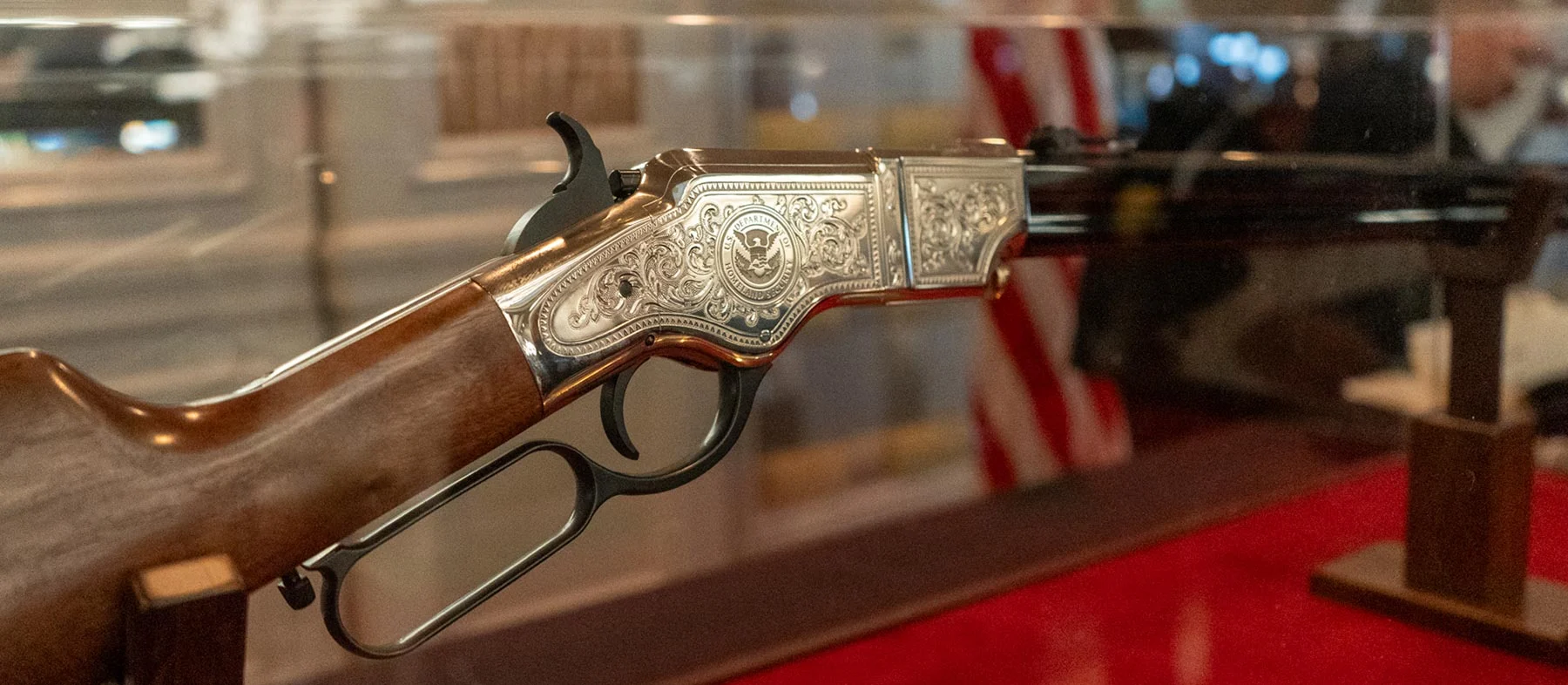 Three men in business suits standing with an award plaque displaying the Henry Repeating Arms logo and branding
