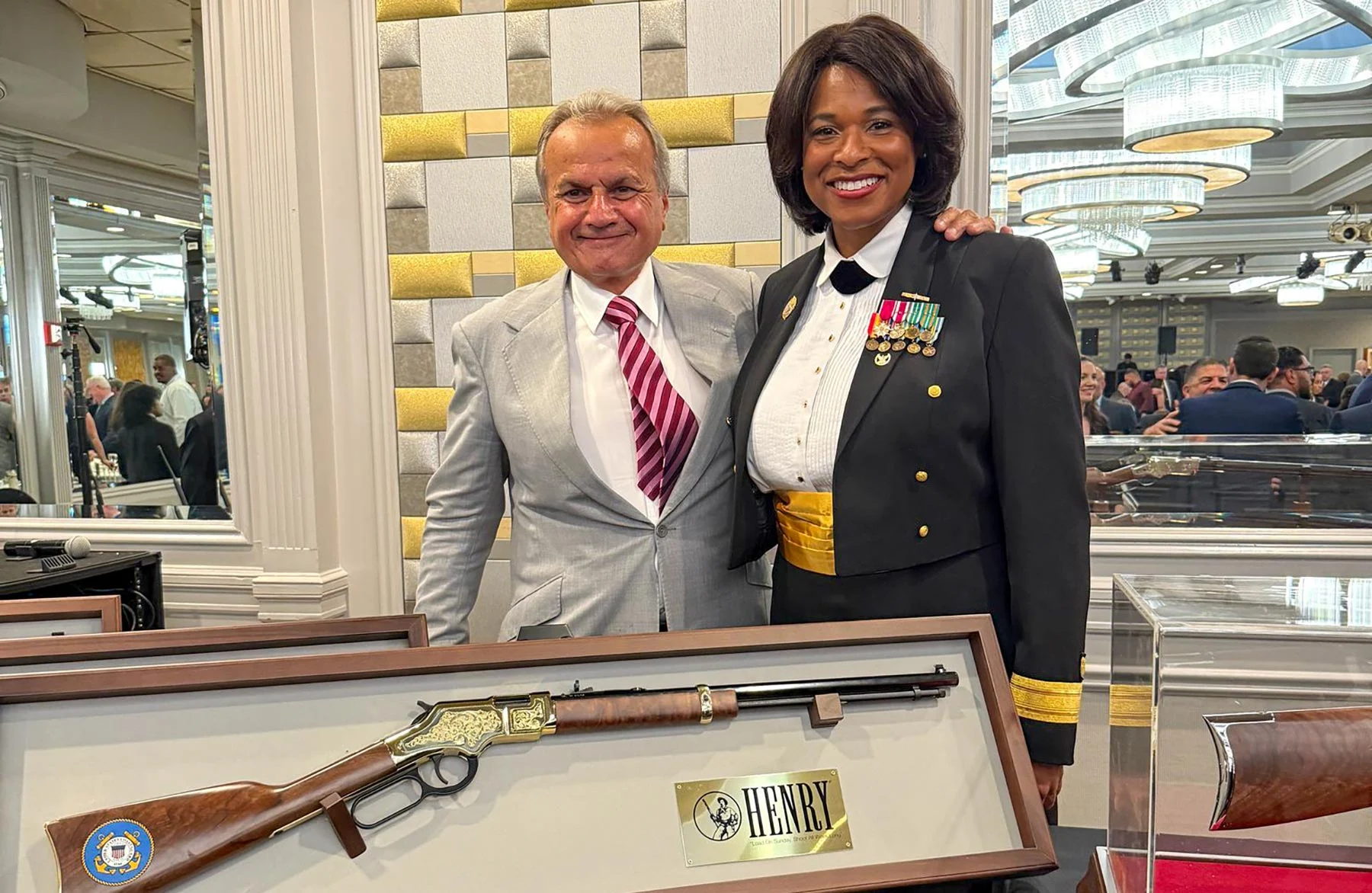 Three men in business suits standing with an award plaque displaying the Henry Repeating Arms logo and branding