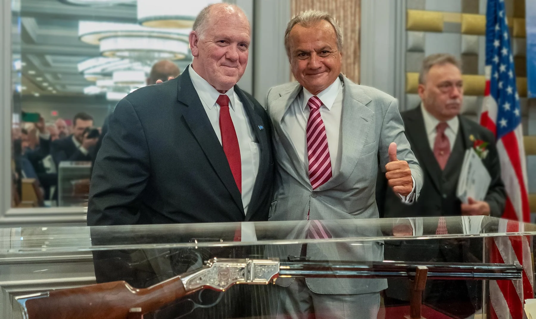Three men in business suits standing with an award plaque displaying the Henry Repeating Arms logo and branding