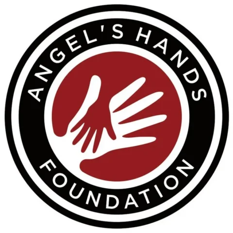 Logo for Angel's Hands Foundation featuring a white hand silhouette inside a red circle, surrounded by black and white rings with the organization name.