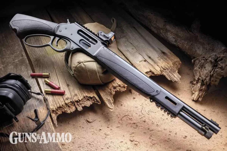 Semi-automatic shotgun laid on weathered wood with ammo shells and hearing protection, Guns & Ammo watermark in corner.