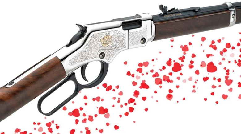 Decorative lever-action rifle with ornate silver engravings and hearts streaming from the barrel, symbolizing love.