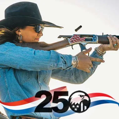 Woman in a denim jacket and wide-brim hat fires a rifle with an American flag motif and a 250 graphic overlay in the foreground.