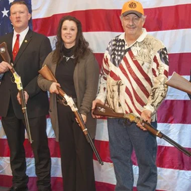 Five local heroes honored with Henry rifles at Great American Outdoor Show, standing in front of American flag