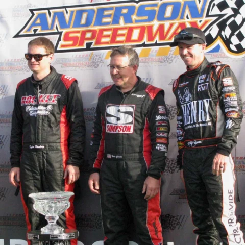 Three racers on the podium at Anderson Speedway, with the Henry Repeating Arms logo visible