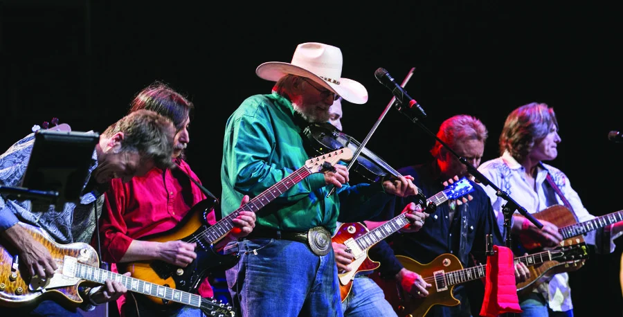 Country music legend Charlie Daniels performing on stage with his band at a live concert