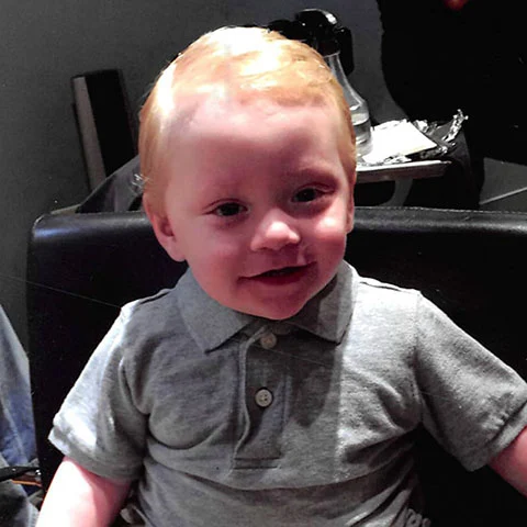 Smiling child in grey shirt, part of Henry Repeating Arms charitable fundraising program