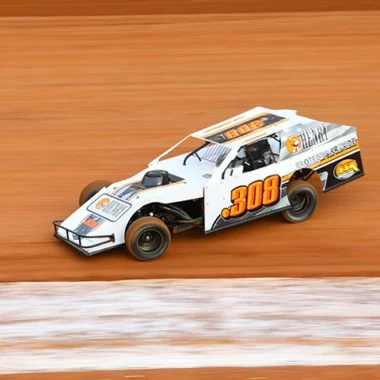 Fast race car with number 308 speeding on dirt track in blurred motion