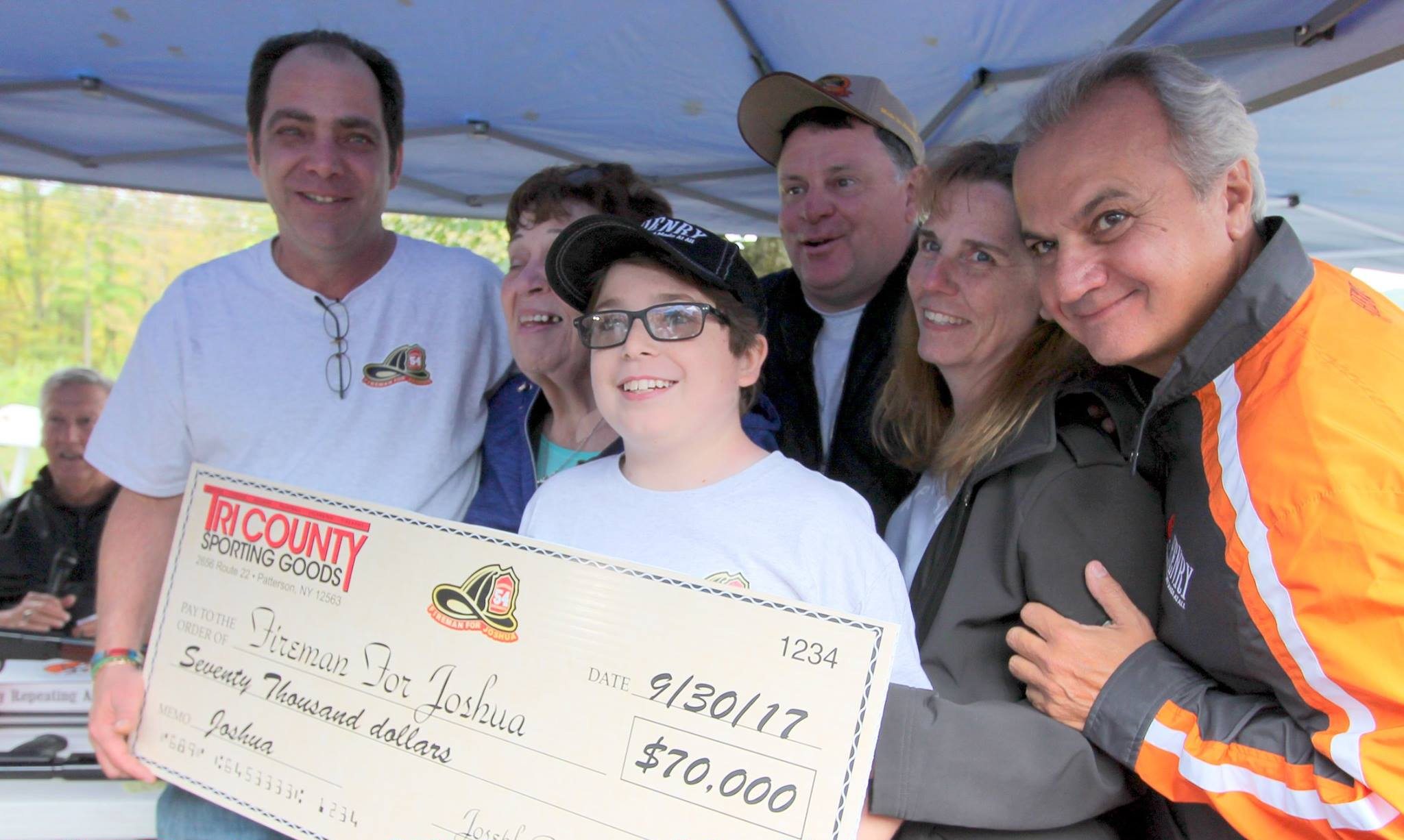 Three men in business suits standing with an award plaque displaying the Henry Repeating Arms logo and branding