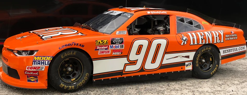 Orange NASCAR race car with Henry Repeating Arms logo and branding