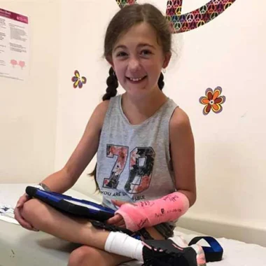 Smiling young girl sitting with medical device or equipment